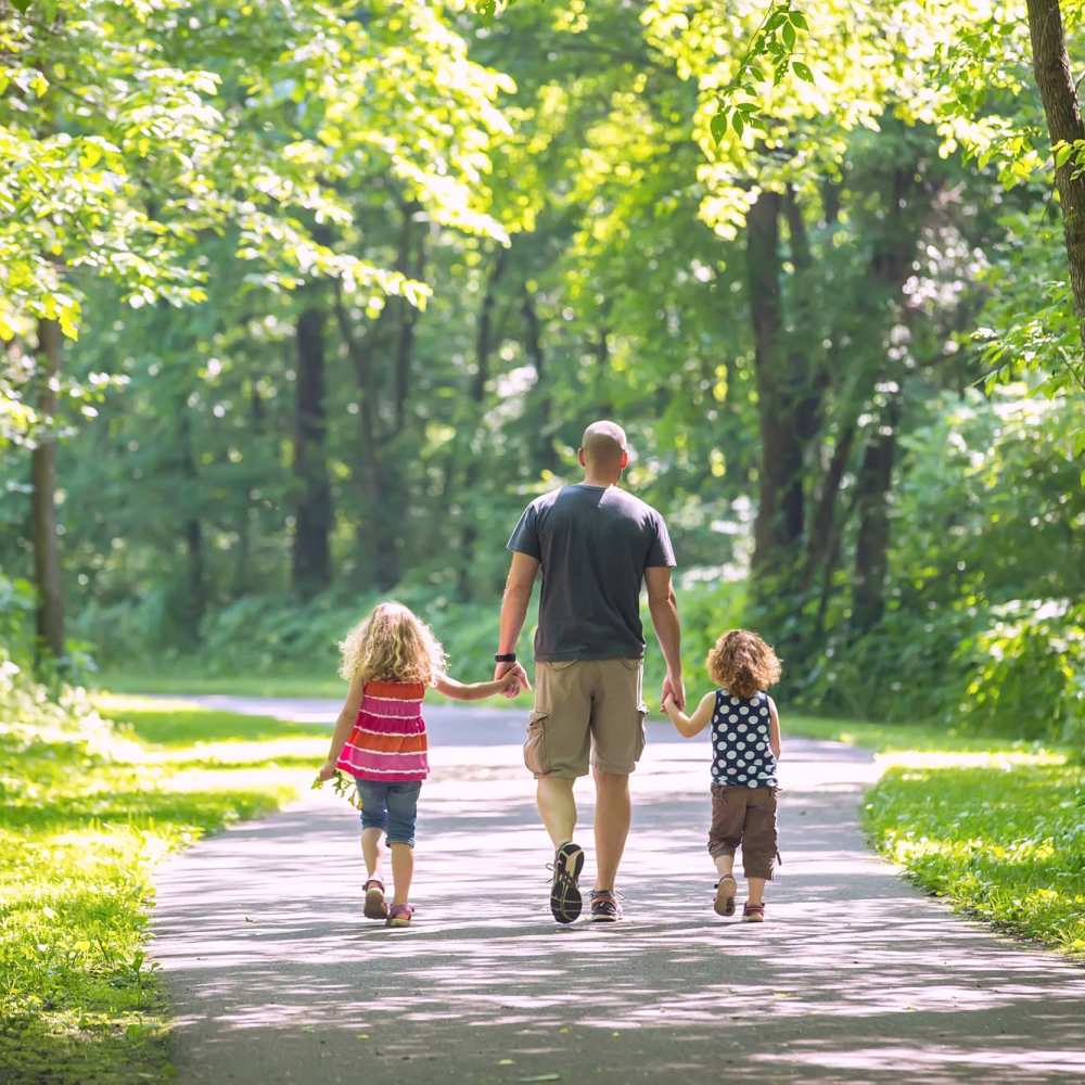 Resident and his children walking near Sycamore Heights Townhomes in Tontitown, Arkansas