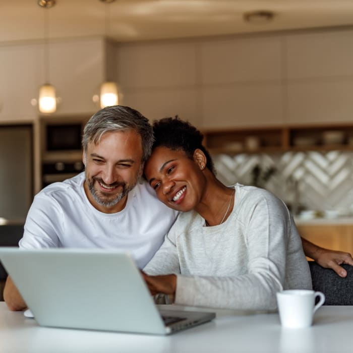 A couple browses the internet on their laptop at Pinnacle Apartments, Hampton, Virginia