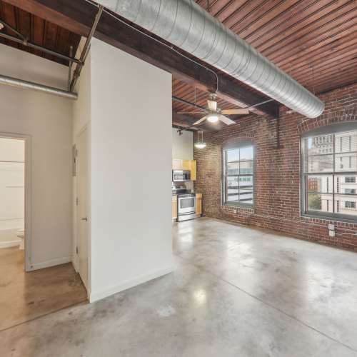 Unfurnished living room with window and air condition duct at Stadium Loft Apartments in Saint Louis, Missouri