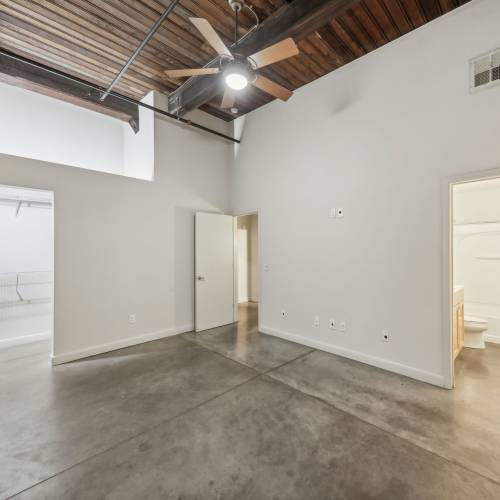 Unfurnished bedroom with attached bathroom and walk-in closet at Stadium Loft Apartments in Saint Louis, Missouri