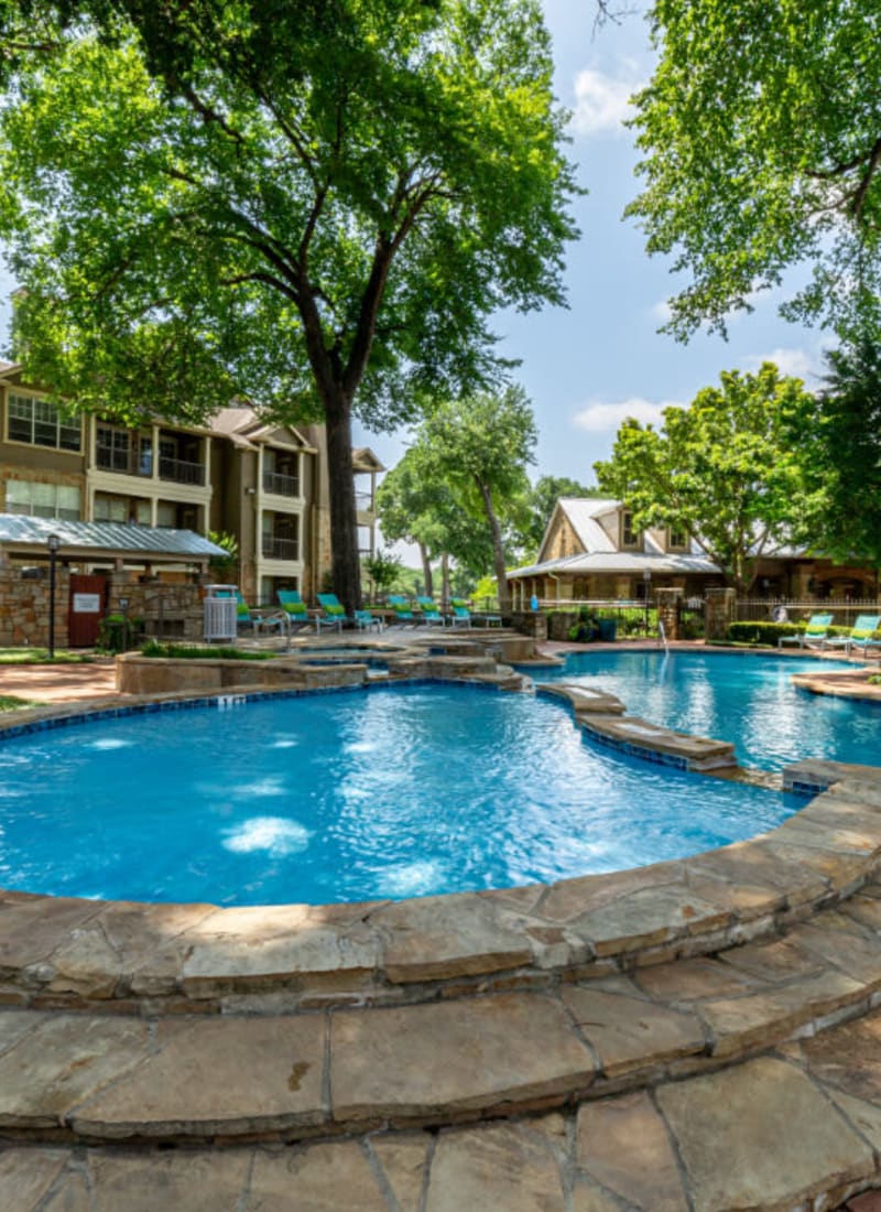 Stone steps to hot tub next to pool at Marquis at Bellaire Ranch in Fort Worth, Texas