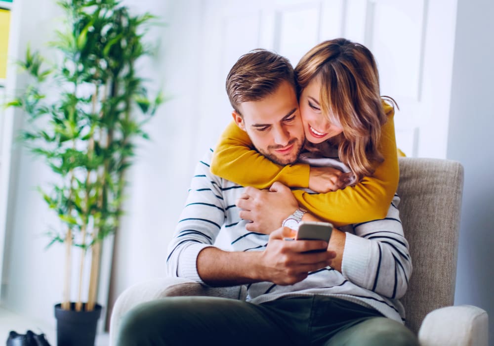 Resident couple filling out a form on our website from a mobile device in their new home at Sofi Highlands in San Diego, California