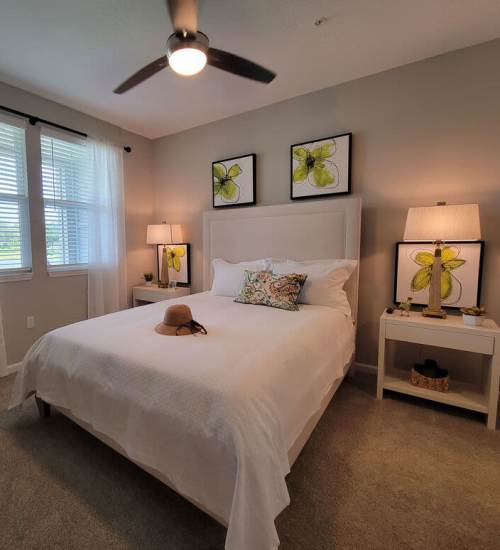 Cozy bedroom with bright windows and stylish decor at Messina Luxury Apartments in New Smyrna Beach, Florida