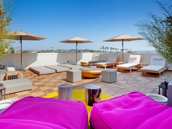 Roof top lounge with umbrellas at Brio Apartment Homes in Glendale, California