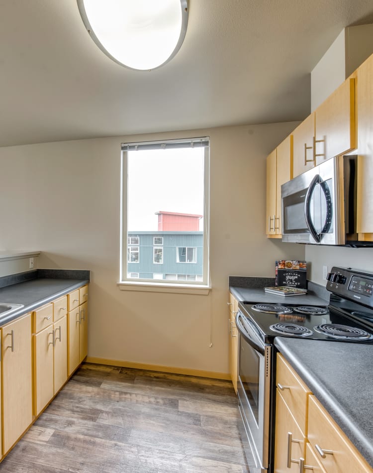 Kitchen with hardwood flooring in a model home at Verse Seattle in Seattle, Washington
