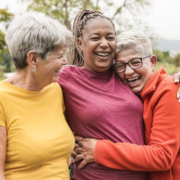 Three residents embracing at Pacifica Senior Living Ellensburg in Ellensburg, Washington