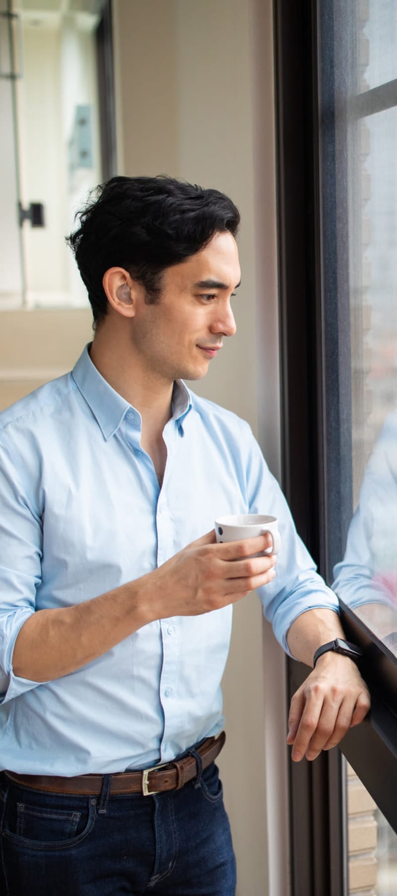 Resident enjoying the view with his morning coffee in his new loft apartment at 17th Street Lofts in Atlanta, Georgia 