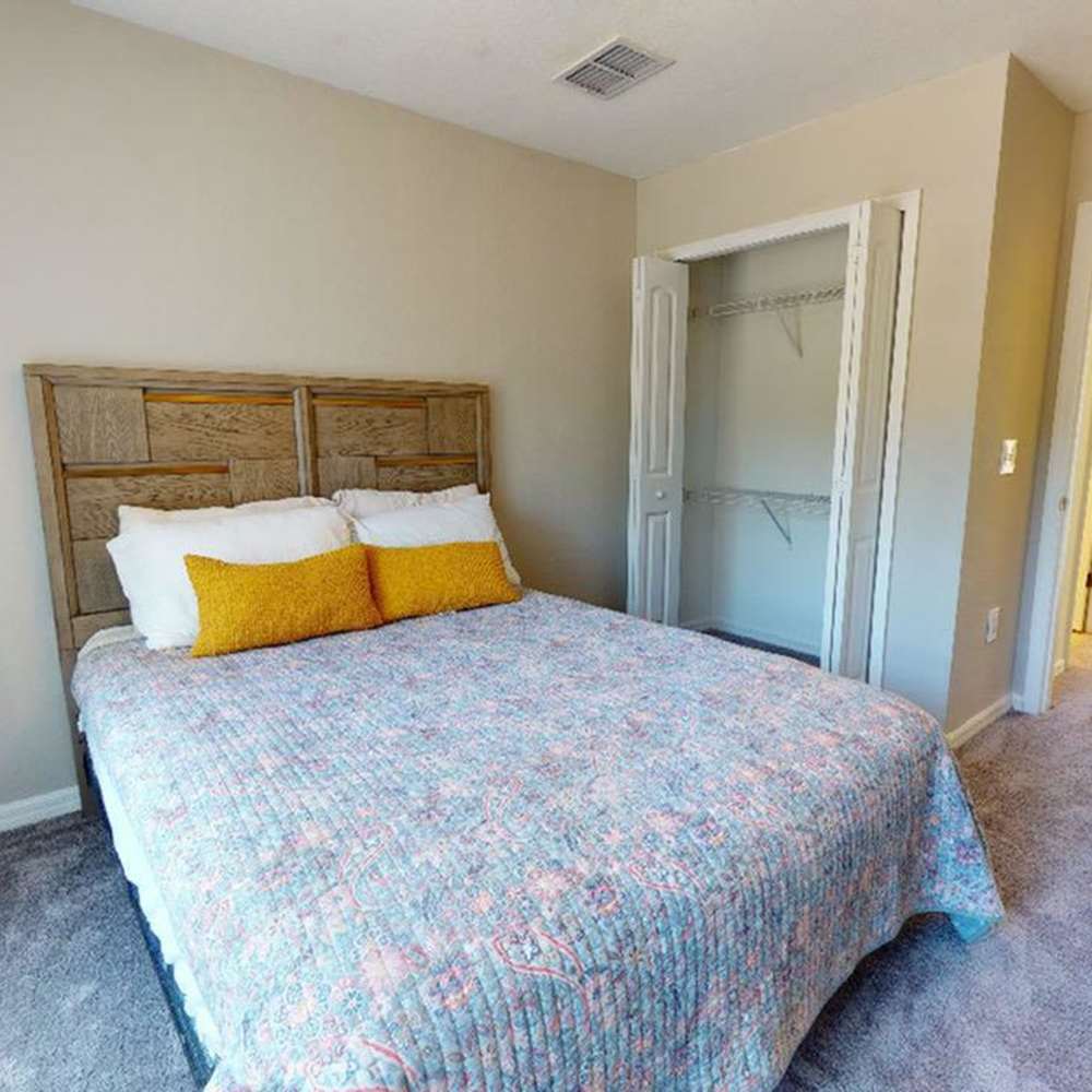 Cozy bedroom with a queen bed, soft carpet, and spacious closet at The Reserve at Brookhaven in Palm Coast, Florida