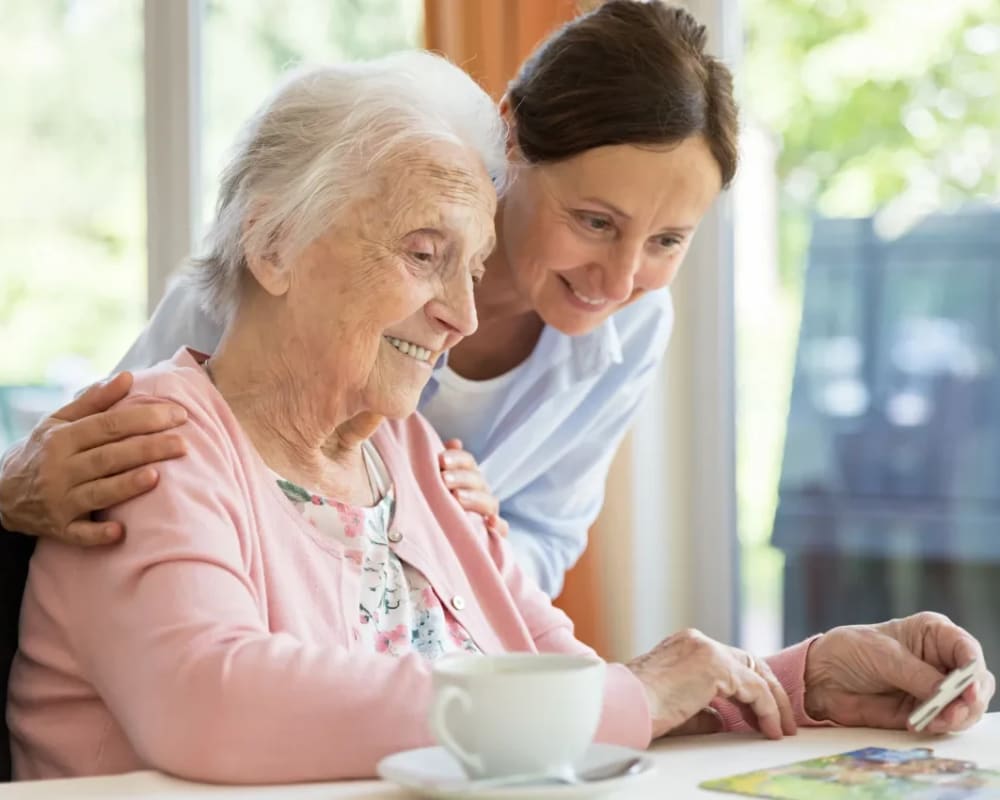 Residents with a jigsaw puzzle in memory care at Sunset Park Place in Dubuque, Iowa.