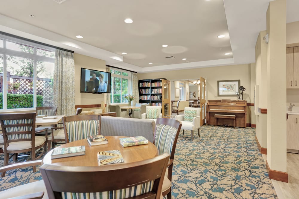 Community seating area with television, piano, and furnishings at The Creekside in Woodinville, Washington