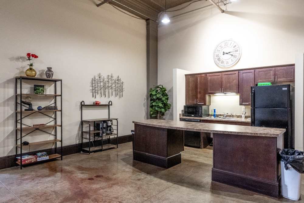 Brown cabinets and a clock on the wall at Rumely Lofts in Des Moines, Iowa