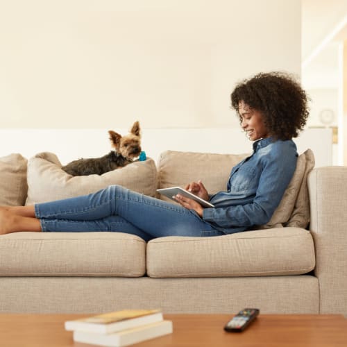 Laying on the couch with her cute little puppy at Madrona Apartments in Washington, District of Columbia