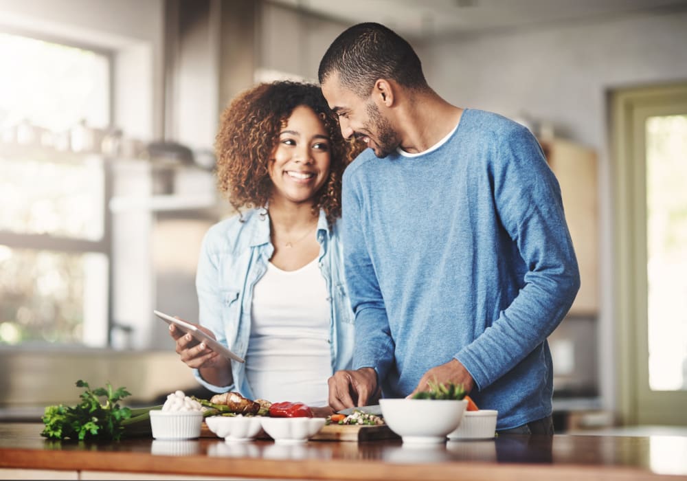 Resident couple cooking a fresh meal in the gourmet kitchen of their new home at Sofi Berryessa in San Jose, California