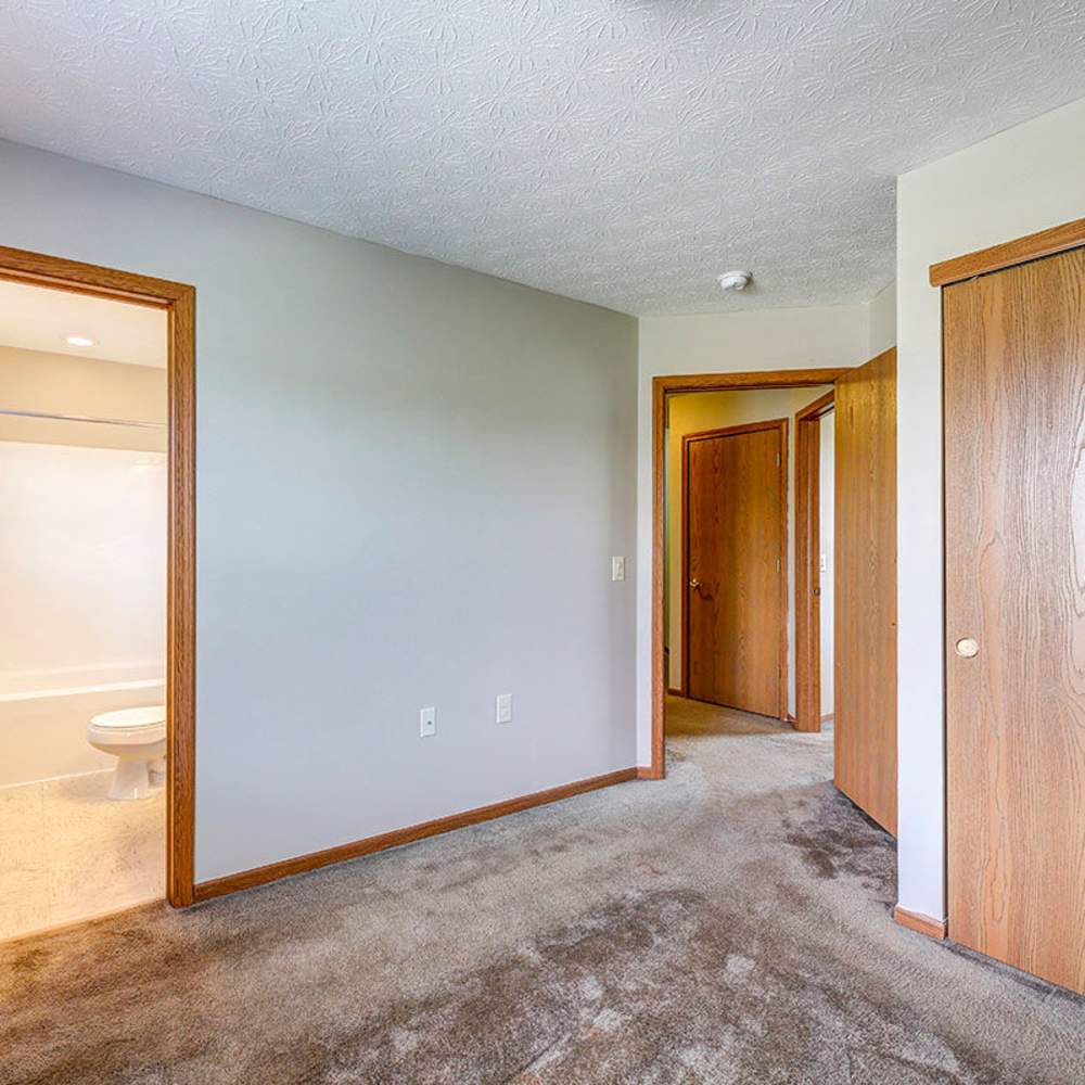 Carpeted room with beige walls and wooden doors at Orchard Glen in Orrville, Ohio