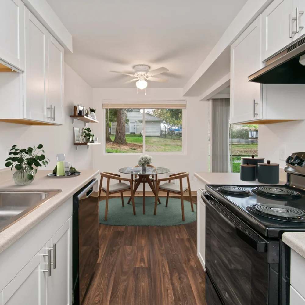 Galley kitchen and dining area of an apartment home at Bluffs at Evergreen in Everett, Washington