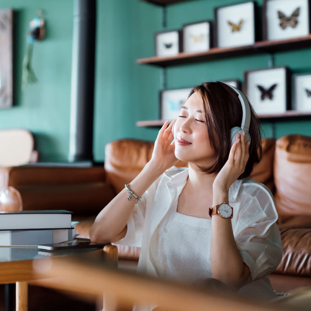 Resident listening to music with her headphones at Le Rivage Luxury Apartments, Bossier City, Louisiana