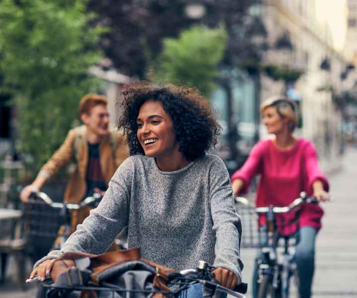 Woman along with her friends riding bicycle downtown near The Falgrove Apartments in Omaha, Nebraska