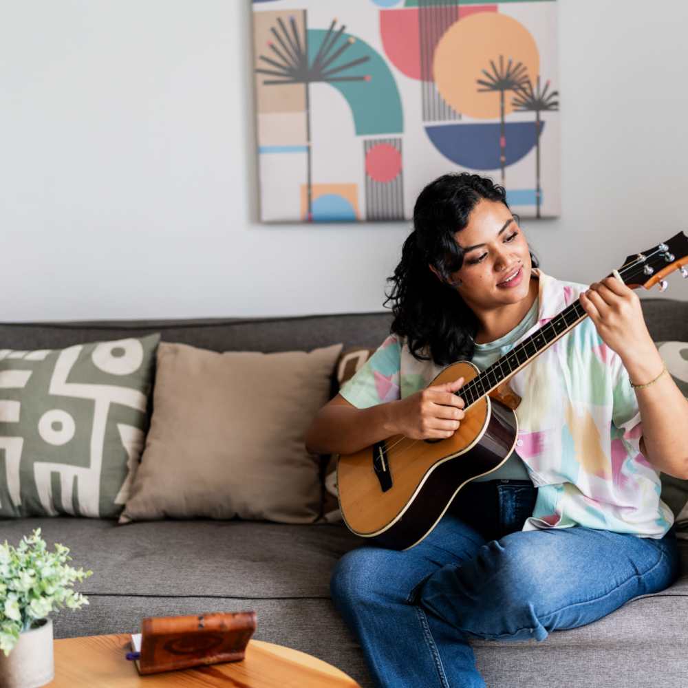 Cozy living area featuring stylish decor and a musician enjoying a relaxing moment at The View at Blue Ridge Commons in Roanoke, Virginia.