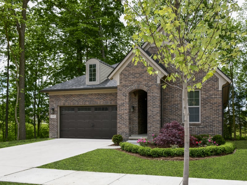 Cottage home with a garage, driveway, and personal lawn at Blossom Ridge in Oakland Charter Township, Michigan