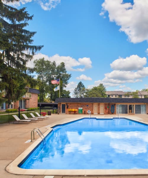 Outdoor swimming pool with expansive sundeck at Kensington Manor Apartments in Farmington, Michigan