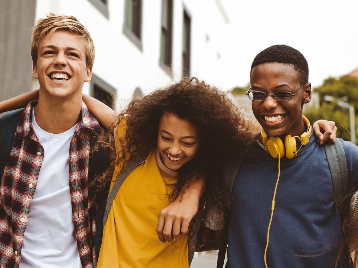 Friends with their arms around each other on the way to class near The Gramercy in Manhattan, Kansas