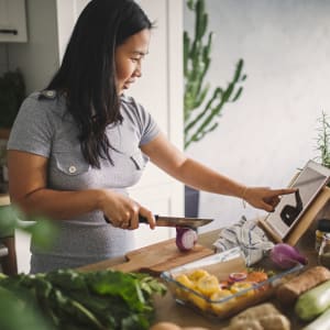 Resident making a meal in her new kitchen at Ridgeway Apartments in Midlothian, Texas