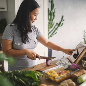 Resident trying out a new recipe in her well-equipped kitchen at Highlands of Grand Prairie in Grand Prairie, Texas