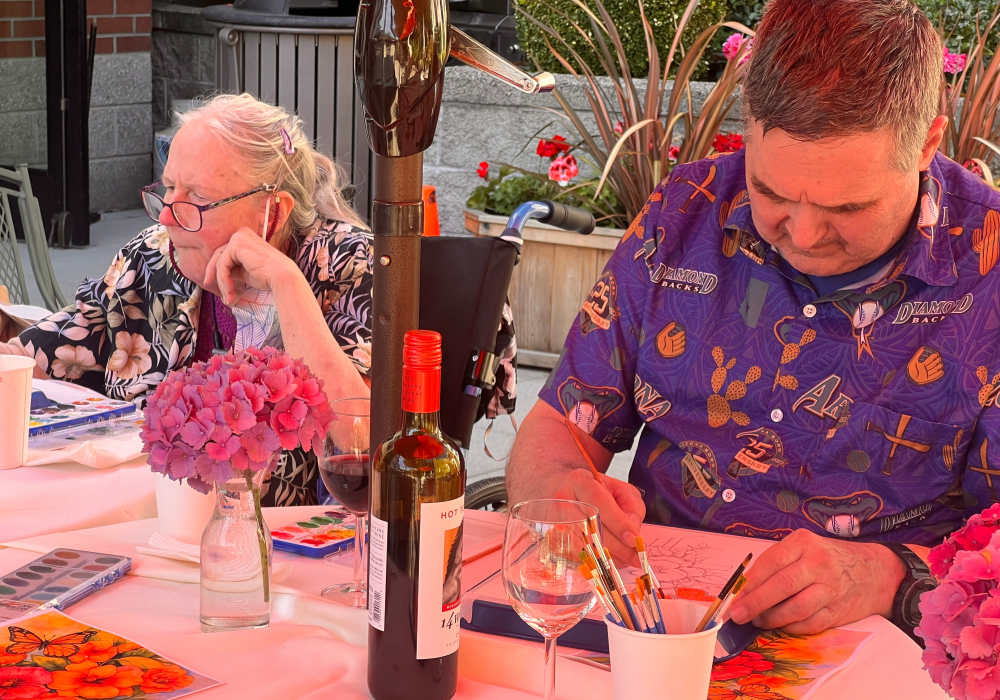 Residents painting while having some wine at Merrill Gardens at The University in Seattle, Washington