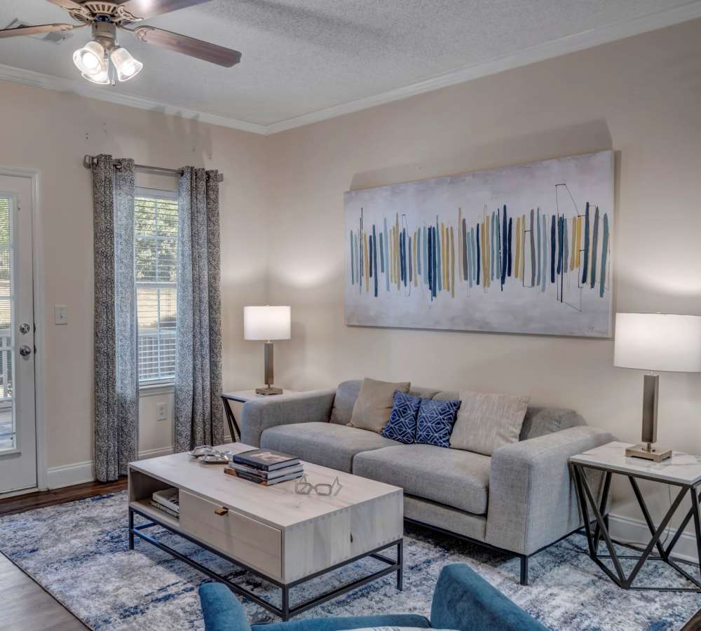A spacious apartment living room with the kitchen in the background at Adrian On Riverside in Macon, Georgia