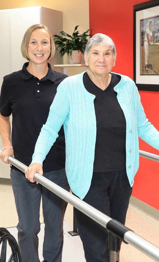 Resident smiling with thearapist in rehabilitation room at Garden View Care Center in St. Louis, MO