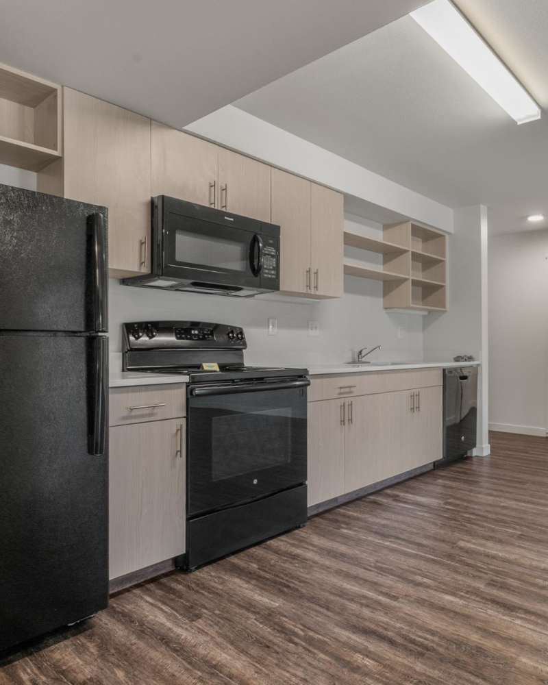 Modern kitchen with wooden cabinets, stainless-steel appliances and granite countertops at Blanton Commons in Beaverton, Oregon
