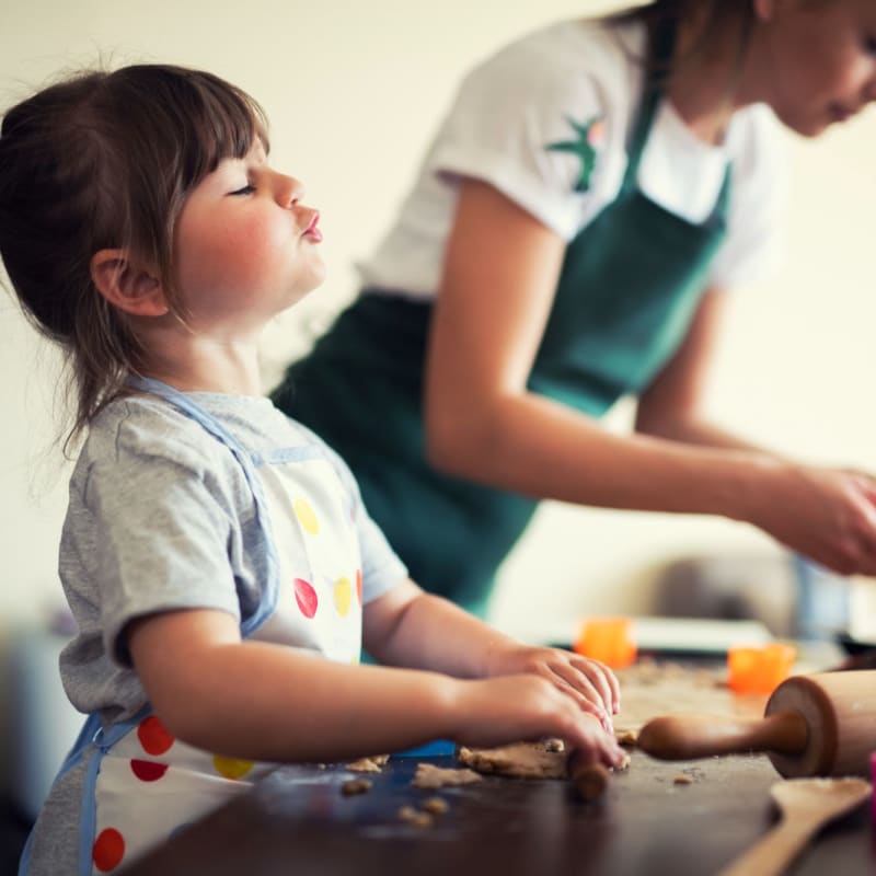 Resident child helping cook at Villas Del Lago in Los Angeles, California