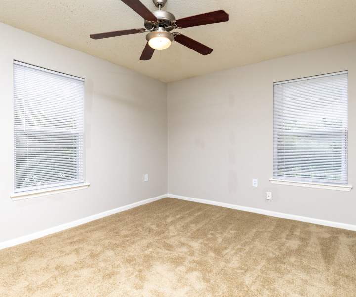 Bedroom with double windows at West Village Apartments in Hillsborough, North Carolina