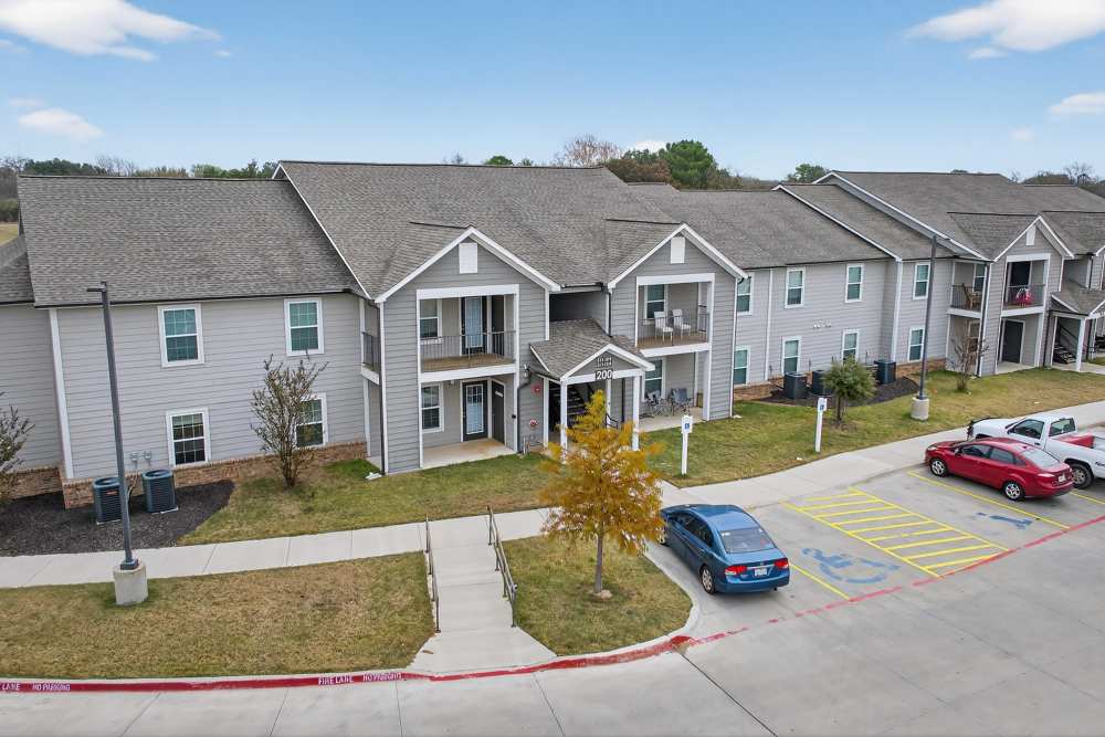Charming apartments with spacious balconies and lush landscaping at Lakewood Crossing in Granbury, Texas