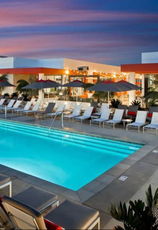 Resort-style swimming pool with lounge chairs at The Marke Apartment Homes in Santa Ana, California