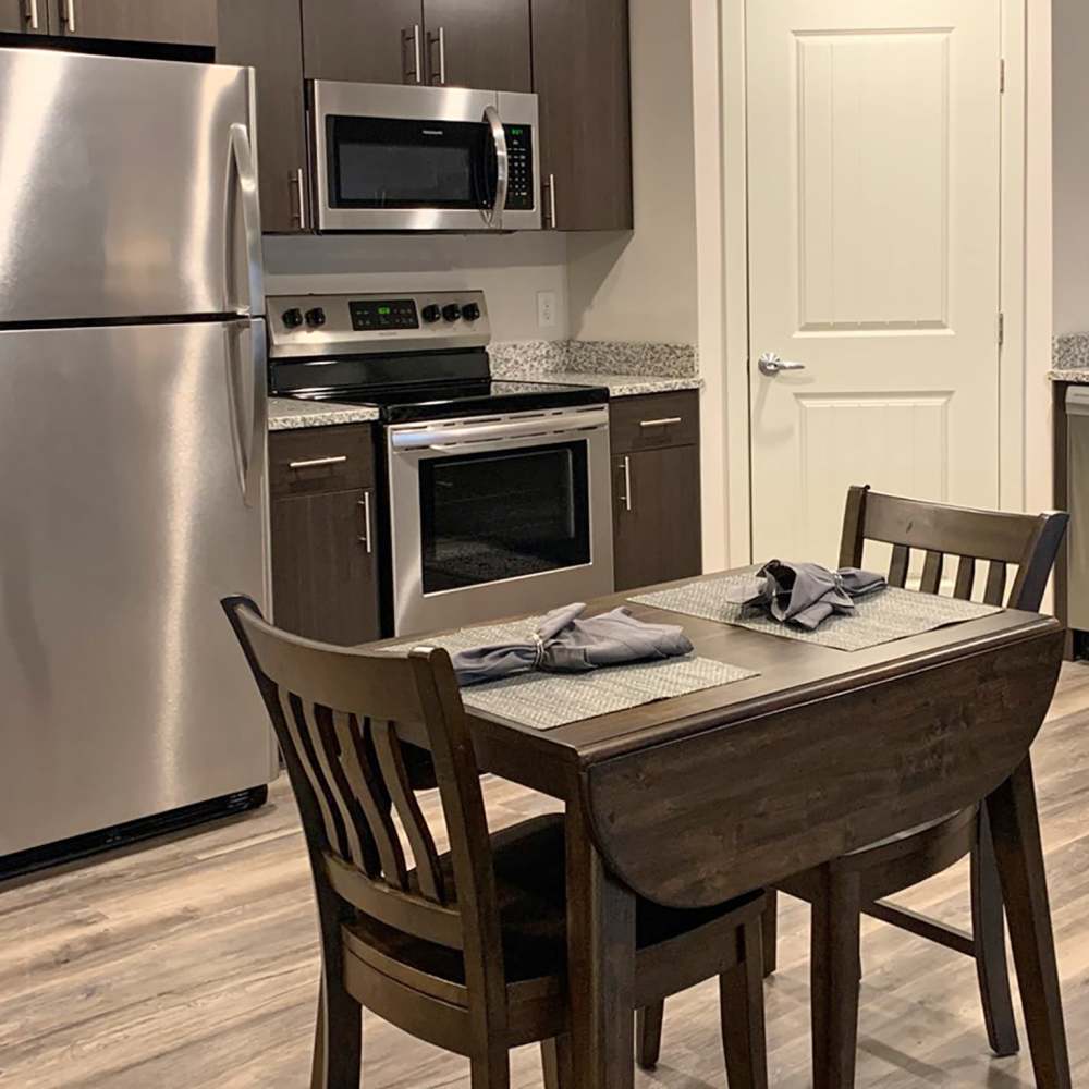 Modern kitchen with fridge, stove and wood cabinet at Depot on Main in Zimmerman, Minnesota