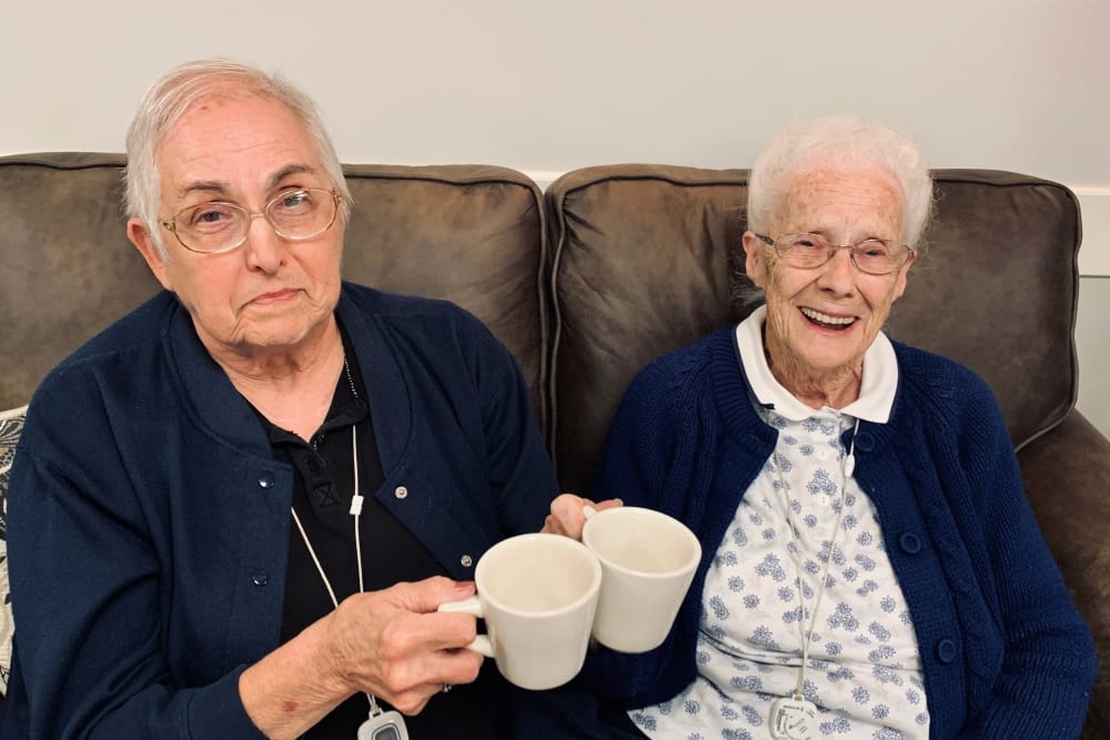 Resident friends give a toast with their coffee cups at Corridor Crossing Place in Cedar Rapids, Iowa
