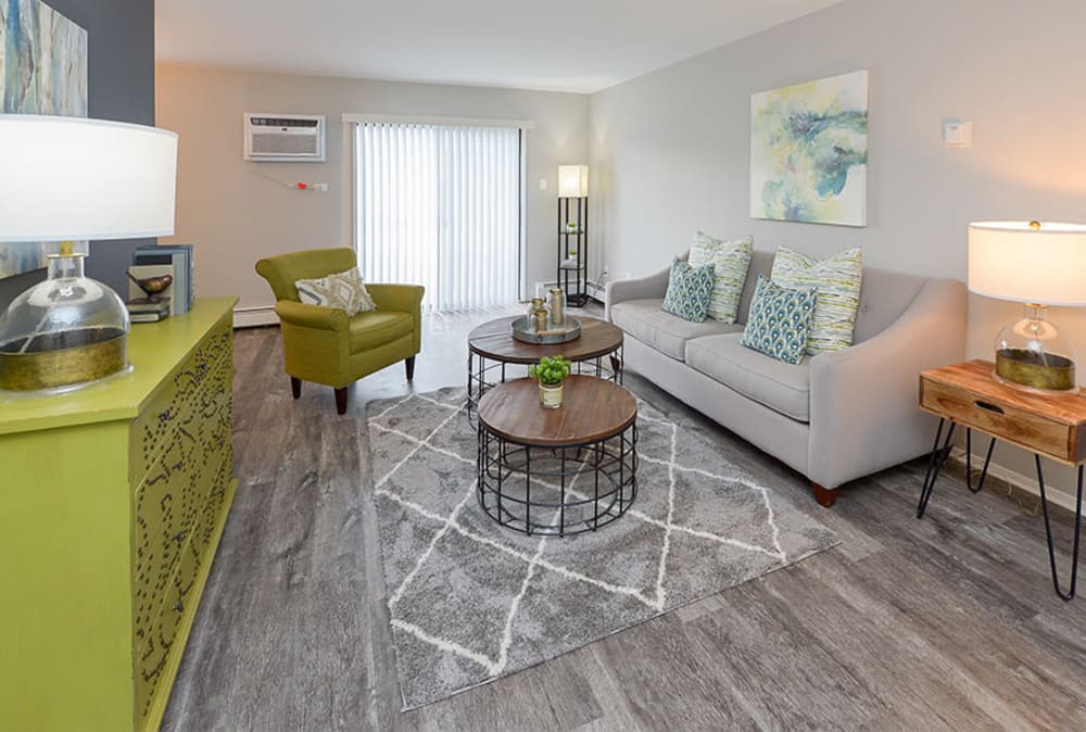 Naturally well-lit living room with vinyl plank flooring at Imperial Gardens Apartment Homes in Middletown, NY