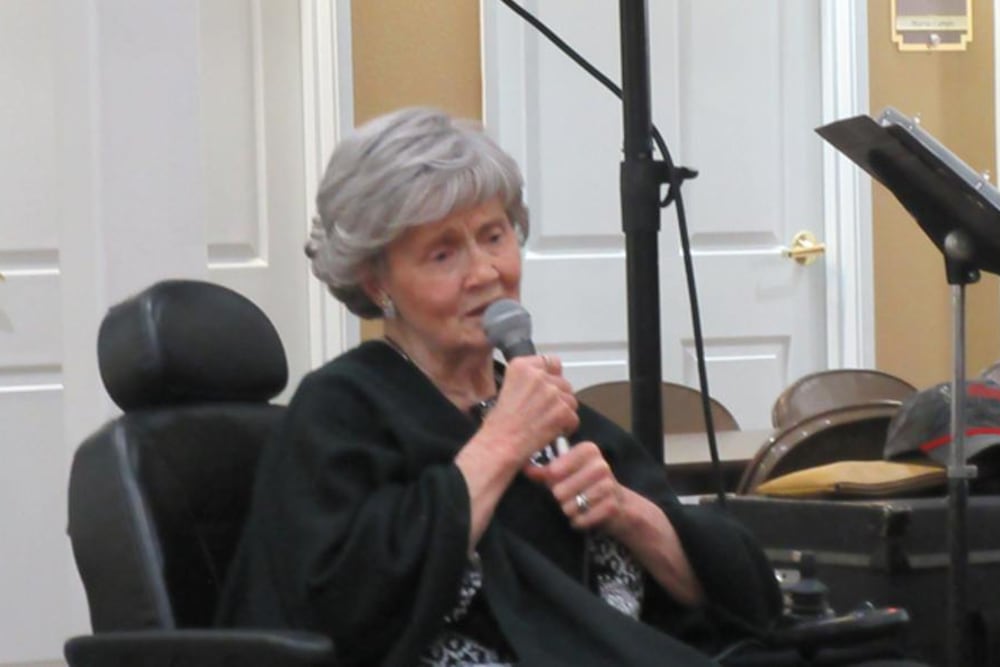 A lady sings to the staff and residents at Garden Square of Greeley Memory Care