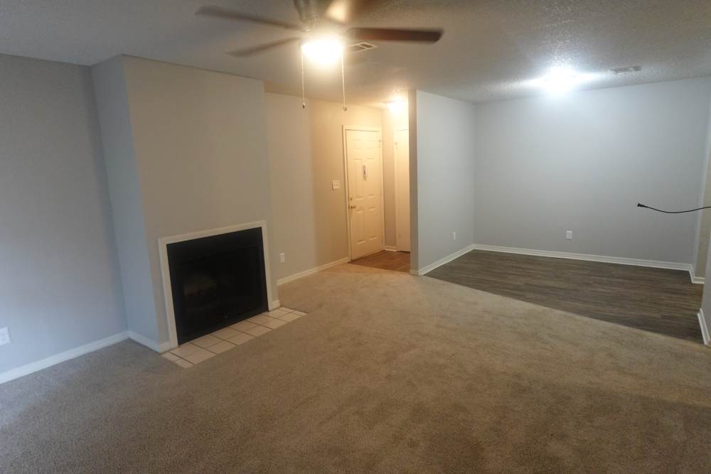 living room with fireplace and ceiling fan at Ember Ridge Apartments in Pensacola, Florida