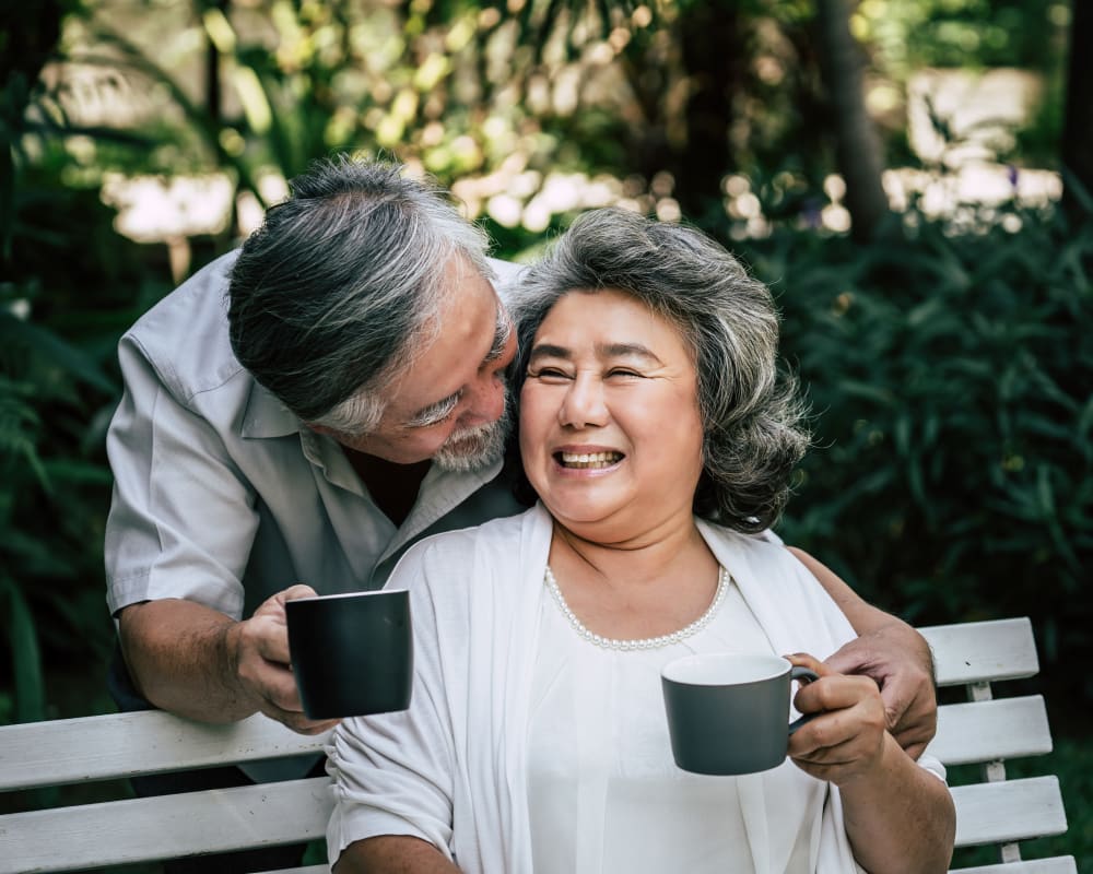 Resident couple enjoys coffee outside at Arlington Place of Red Oak in Red Oak, Iowa.