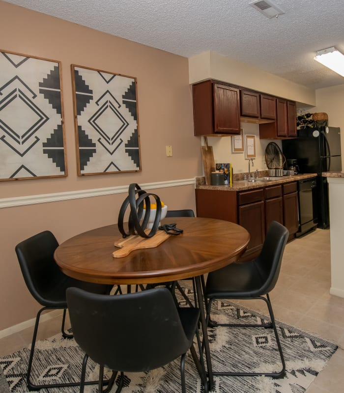 Dining area with kitchen cabinets at back at Sugarberry Apartments in Tulsa, Oklahoma