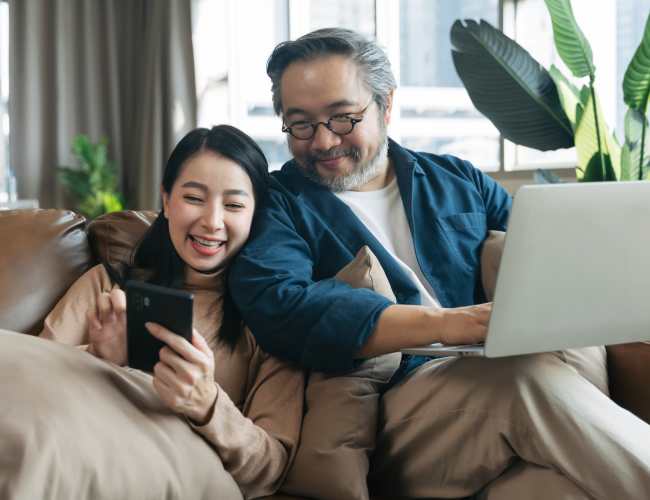 Cozy living room with relaxed couple using devices on a sofa at Tesoro Del Valle in Los Angeles, California