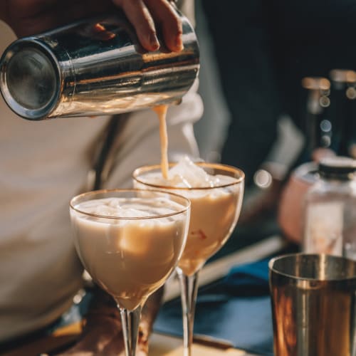 Two cocktails being poured by a local mixologist near The Mallory in Raleigh, North Carolina