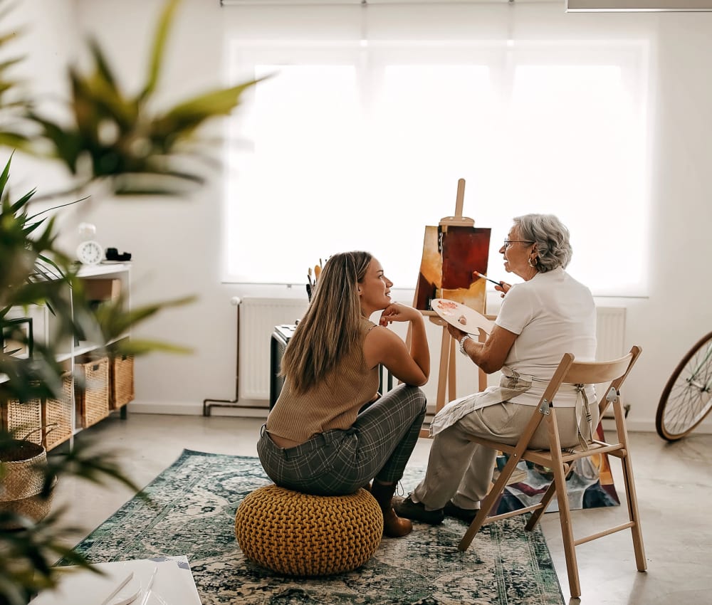 Woman working on a painting in her apartment at The Village of Southampton in Houston, Texas