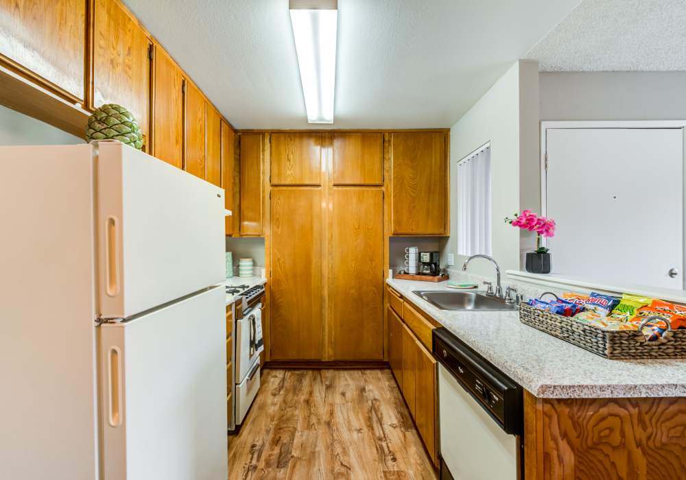 Well-furnished kitchen with wooden cabinets and energy-efficient appliances at The Villas at Rowland Heights in Rowland Heights, California
