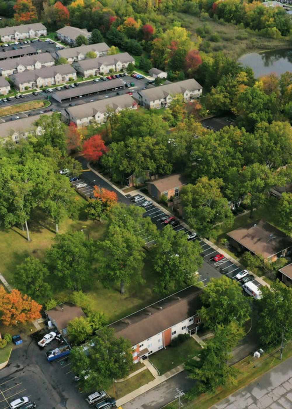 Aerial view of charming homes surrounded by lush landscaping and vibrant autumn colors at The Reserve at Pin Oak Manor Apartments in Mishawaka, Indiana.