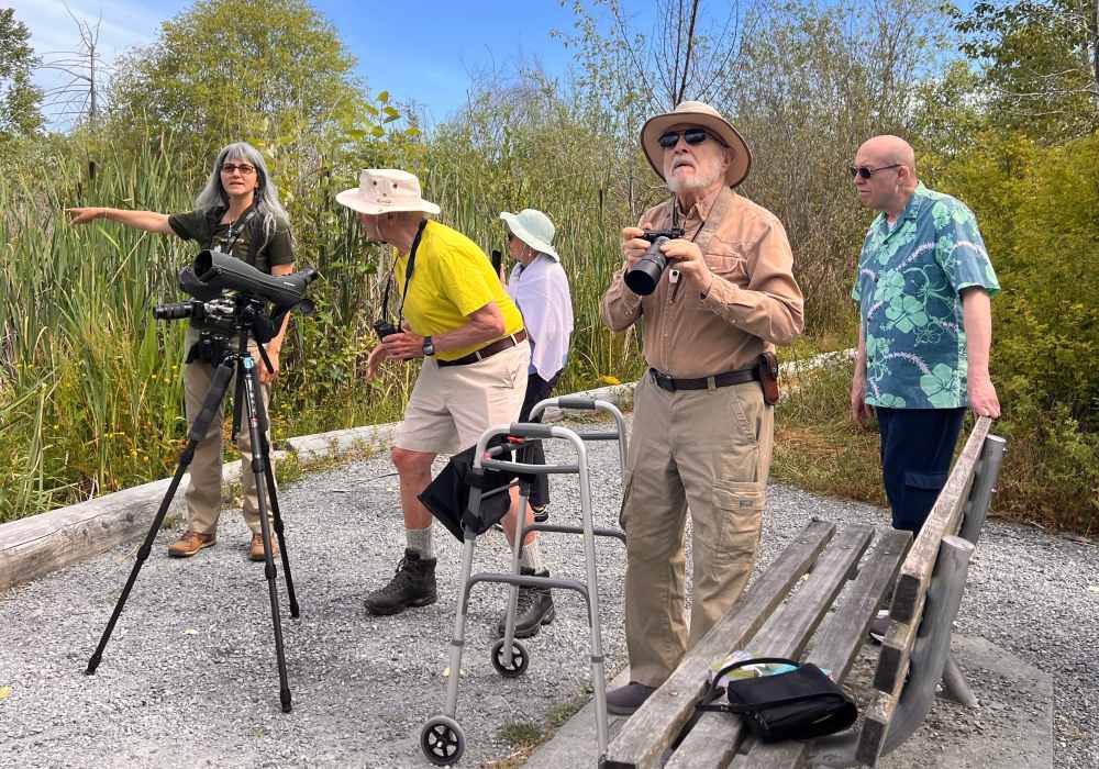 Residents taking photos outdoors near Merrill Gardens at The University in Seattle, Washington