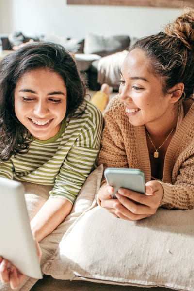 Residents spreading out on the floor and surfing the web on a laptop in their spacious home at Solera at City Centre in Palm Beach Gardens, Florida