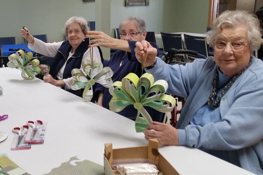 Residents showing off craft projects at Prairie Meadows Senior Living in Kasson, Minnesota.